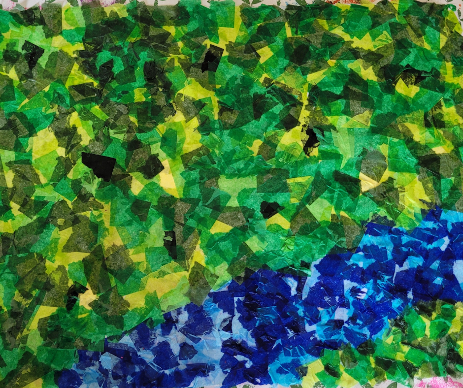 An image of the finished dinosaur habitat background. It is a large piece of paper that has been collaged with greens and blues to make a grassy area and a river area for the dinosaurs.